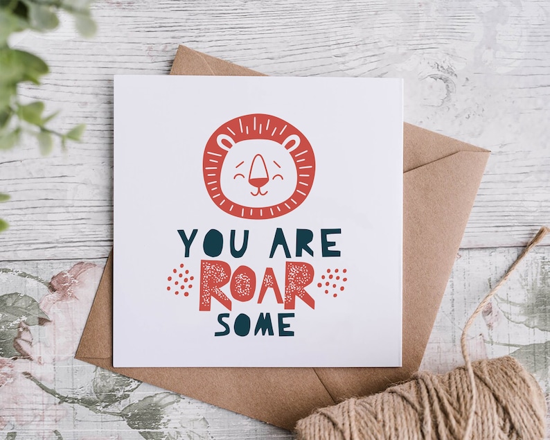 May include: A white card with a red lion face illustration and the text "You are roar some". The card is on a brown envelope with twine.
