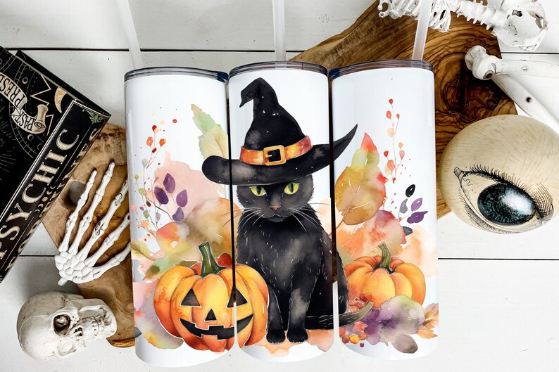 May include: White insulated tumblers with a Halloween theme. Each tumbler features a watercolor design of a black cat wearing a witch hat, pumpkins, and autumn foliage. The tumblers have a straw and a lid.