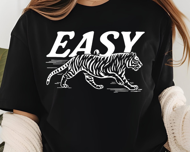 May include: Black t-shirt with the word "EASY" in white block letters above a white tiger illustration. The tiger is walking with its stripes visible.