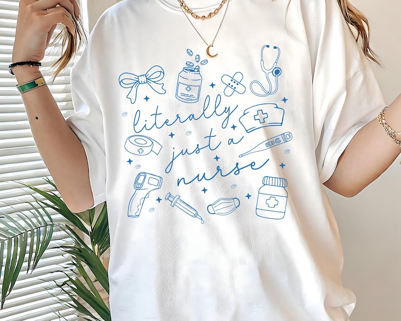 May include: White t-shirt with a blue illustration of medical supplies and the text "literally just a nurse". The design includes a bow, medicine bottles, bandages, a stethoscope, a nurse's hat, a thermometer, and a syringe.