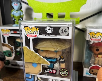 May include: A clear plastic display case with a gray base, showcasing a limited edition 8-bit Pop! Vinyl figure of Raiden from Mortal Kombat X. The figure is wearing a blue and yellow outfit with a yellow hat. The case has a sticker that says "Limited Edition Glow Chase" and "Only at GameStop".