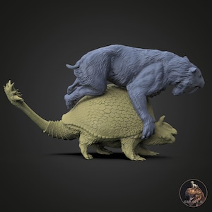 Può includere: Scultura dettagliata di una tigre dai denti a sciabola sopra un anchilosauro. La tigre è di un blu tenue, mentre l'anchilosauro è di colore beige chiaro. La scultura è su uno sfondo grigio scuro.