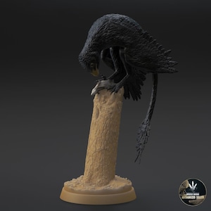 May include: A black bird figurine perched on a tree stump, with a smaller bird figurine in its talons. The bird has a long tail and feathery wings. The base of the figurine is a circular platform.