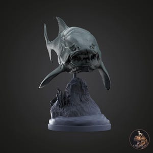 May include: A detailed, grey sculpture of a prehistoric fish head with sharp teeth and fins. The sculpture is mounted on a textured, rocky base and a circular platform. The artwork is set against a dark grey background.