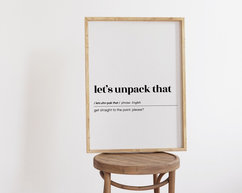 May include: A framed print with the text "let's unpack that" and the definition "get straight to the point, please?" in black text on a white background.