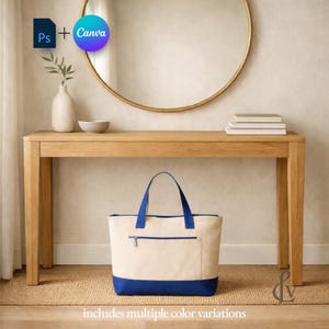 May include: A canvas tote bag with a cream-colored body and a blue base and handles. The bag has a zippered pocket and is sitting on a woven rug in front of a wooden console table. The text "includes multiple color variations" is at the bottom.