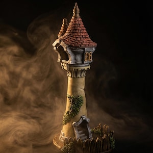 Op de afbeelding: Een gedetailleerde miniatuurtoren met een rood pannendak, kleine ramen en een puntige torenspits. De toren is beige met groene bladaccenten en een kleine deuropening. De basis heeft een houten hekontwerp. De achtergrond is donker met een rokerig effect.