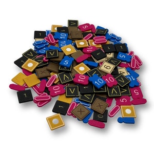 May include: A pile of colorful game pieces with numbers and letters printed on them. The pieces are made of foam and have a variety of shapes, including squares, circles, and rectangles.