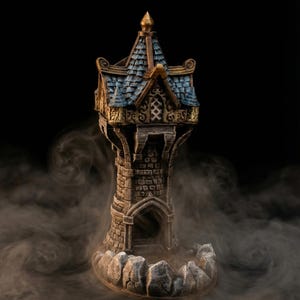 Può includere: Una torre fantasy in miniatura con tetto di tegole blu, finiture dorate e facciata in pietra. La torre ha un ingresso ad arco e poggia su una base rocciosa, circondata da volute di fumo su sfondo nero.