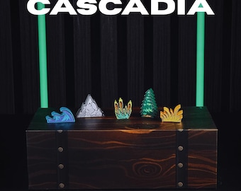 Puede incluir: Una caja de madera oscura exhibe pegatinas coloridas para meeples, incluyendo una ola, una montaña y varias plantas. La palabra "Cascadia" está encima de las pegatinas, con el texto "Stickers for Meeples" debajo. El fondo es oscuro con luces de neón verdes.