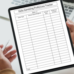 May include: A digital tablet displaying a daily gambling profit and loss tracker. The tracker has columns for date, game type, amount spent or wagered, amount won, and profit or loss amount. The tablet has a white stylus next to it.