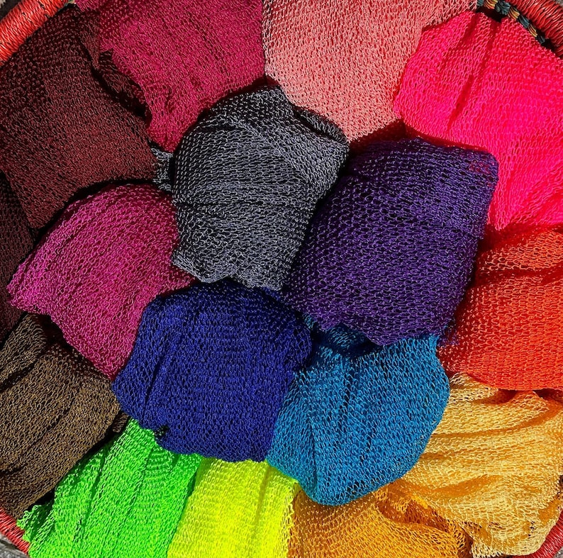 May include: A collection of colorful, textured, knitted fabric pieces in various shades of pink, purple, blue, green, brown, and orange. The fabrics are arranged in a circular pattern, showcasing their unique textures and vibrant hues.  These tightly woven, netted fabrics are ideal for various crafting and textile projects.