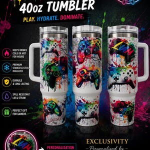 May include: Three 40oz stainless steel tumblers with handles, featuring a white base with colourful paint splatter patterns and graphic illustrations of gaming controllers. The tumblers include clear lids and are decorated with vibrant, multi-coloured ink drips.