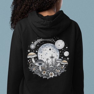 May include: Black hooded sweatshirt with a graphic print of mushrooms and a crescent moon with stars on the back.