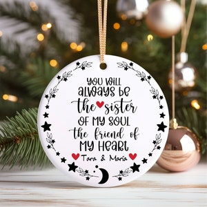 May include: White ceramic ornament with black text and a red heart. The text reads "You will always be the sister of my soul the friend of my heart Tara & Maria".