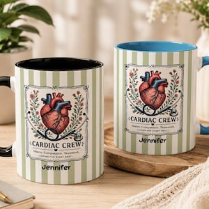 May include: Two ceramic mugs with a medical theme. Each mug features a heart illustration, the words "CARDIAC CREW", and the name "Jennifer". The mugs have a striped pattern and contrasting handle and interior colors.