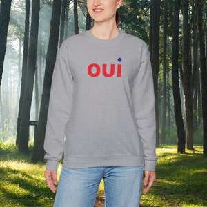 May include: A gray sweatshirt with the word "oui" in red letters and a blue dot above the "i".