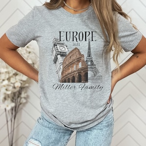 May include: Gray t-shirt with a graphic of the Eiffel Tower, Big Ben, and the Colosseum. The text "Europe 2024" and "Miller Family" is printed on the shirt.