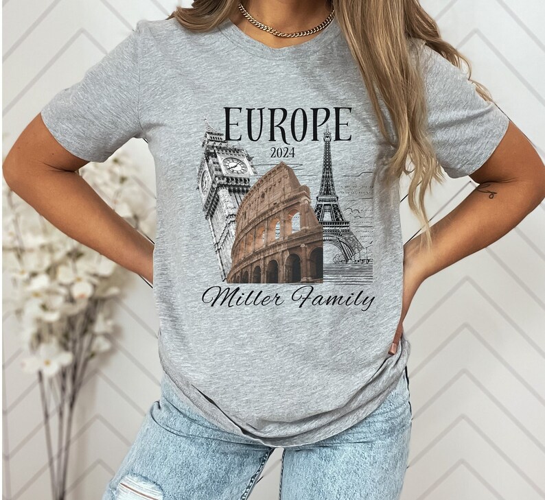 May include: Gray t-shirt with a graphic of the Eiffel Tower, Big Ben, and the Colosseum. The text "Europe 2024" and "Miller Family" is printed on the shirt.