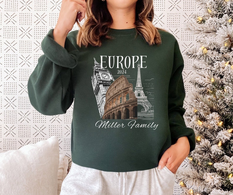 May include: A dark green sweatshirt with a white graphic design featuring iconic European landmarks, the text "Europe 2024", and the words "Miller Family".