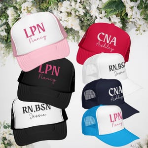 May include: A collection of trucker hats in various colors, including pink, red, black, white, and blue. Each hat features the text "LPN," "CNA," or "RN, BSN" along with a name in a contrasting color. The hats have a mesh back.
