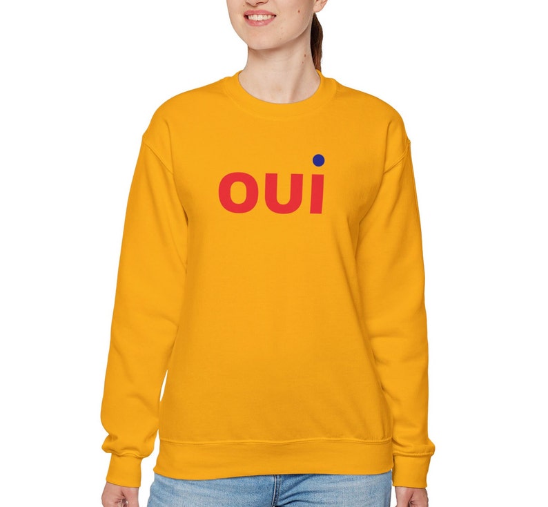 May include: A yellow sweatshirt with the word "OUI" in red letters and a blue dot above the "I".
