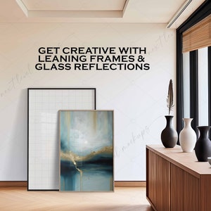 Może przedstawiać: Biała ściana z tekstem "GET CREATIVE WITH LEANING FRAMES & GLASS REFLECTIONS" w kolorze czarnym. Biała rama z siatką opiera się o ścianę obok abstrakcyjnego obrazu w kolorze niebieskim i złotym w drewnianej ramie. Przed ścianą stoi drewniana komoda z trzema wazami i miską.