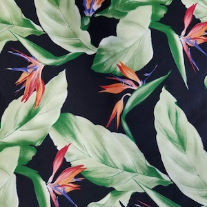 Brilliant tropical birds of paradise in orange, green and black cotton fabric