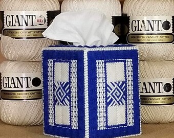 May include: A blue and white crocheted tissue box cover with a geometric pattern. The cover is sitting on a shelf with several spools of white yarn labeled "GIANT" mercerized crochet cotton.