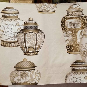 May include: A beige fabric with a repeating pattern of brown and white Chinese-style vases. The vases have intricate floral and geometric designs.