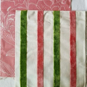 May include: Two fabric swatches, one with a pink floral pattern and the other with white fabric and green and pink stripes.