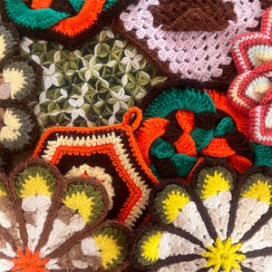 May include: A collection of crocheted pot holders in various colors and patterns, including green, orange, brown, yellow, and white. The pot holders are shaped like flowers, squares, and circles.