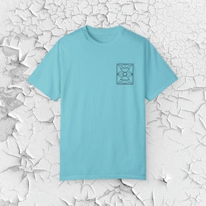May include: A light blue t-shirt with a black geometric design on the front.