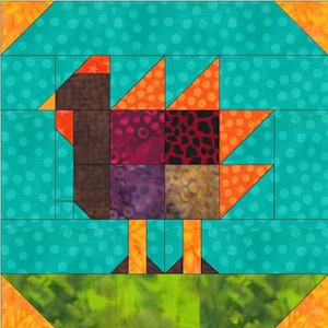 May include: A patchwork quilt block featuring a turkey design. The turkey is brown, orange, red, purple, and black. The turkey is standing on a green field.