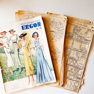 Könnte beinhalten: Vintage Schnittmuster und eine Modezeitschrift. Das Magazincover zeigt Illustrationen von Frauen in Kleidern. Das Magazin trägt den Titel "NEUE MODEZEITUNG ERGON Nr. 15". Die Schnittmuster sind beige mit schwarzen Diagrammen.