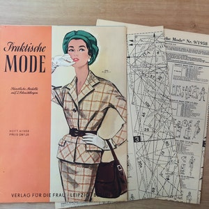 May include: A vintage sewing pattern booklet titled "Praktische MODE" with a fashion illustration of a woman in a plaid suit. The booklet is orange and white with German text. Pattern sheets are visible.