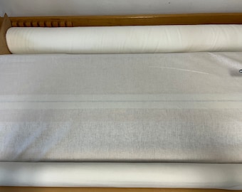 May include: A white fabric roll on a wooden surface. The fabric is smooth and appears to be linen.