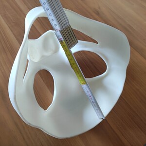 May include: White plastic mold with two large holes and a smaller hole in the center. A yellow measuring tape is placed across the mold, with the numbers 10, 11, 12, 13, 14, 15, 16, 17, 18, 19, 20, 21, 22, 23, 24, 25, 26, 27 visible.
