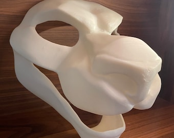 Könnte beinhalten: Weiße, unfertige Felltiermaske mit einer großen Schnauze und offenem Maul. Die Maske besteht aus einem glatten, harten Material und ist bereit zum Bemalen.