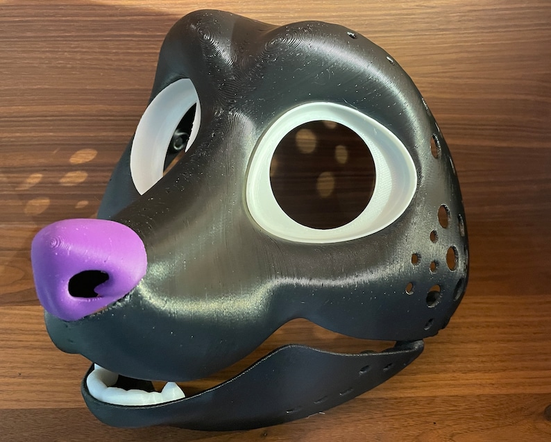 May include: A black and white furry mask with a purple nose and a white eye area. The mask has a textured surface and is designed for cosplay or furry fandom.