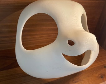 May include: White unfinished resin blank fursuit head base with eye and mouth openings. The head base has a sculpted nose and a slightly smiling expression.