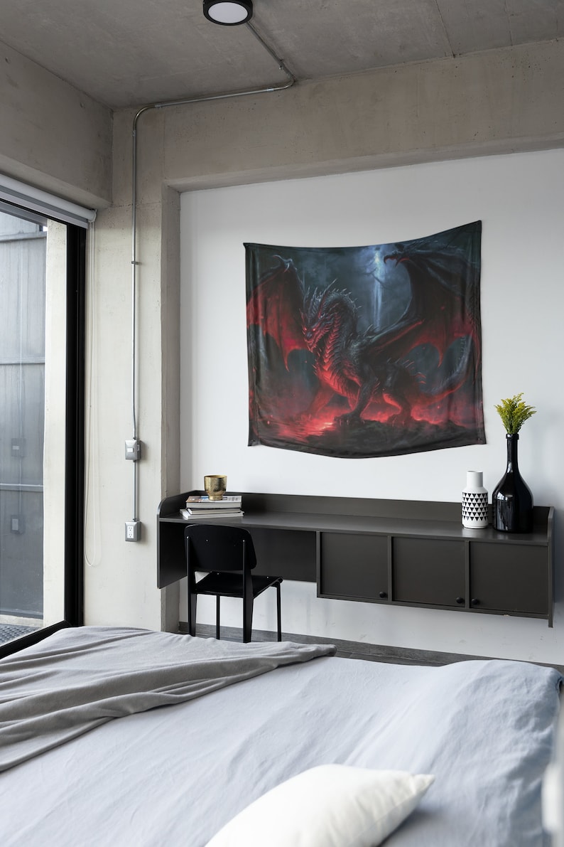 Puede incluir: Un tapiz de drag&oacute;n rojo colgado en una pared blanca en un dormitorio moderno. El tapiz presenta un drag&oacute;n rojo con alas negras y un fondo de fuego.