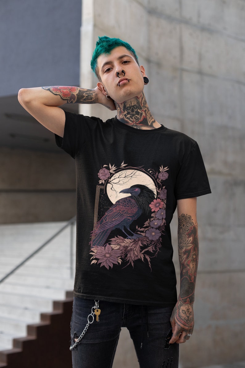 May include: Black t-shirt featuring a graphic print of a raven perched on a branch with flowers and a moon in the background.