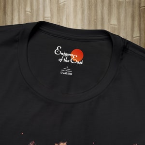 May include: Black t-shirt with a white label that says "Enigma of the East" with a red circle. The label also says "100% Cotton" and "Made in Bangladesh".
