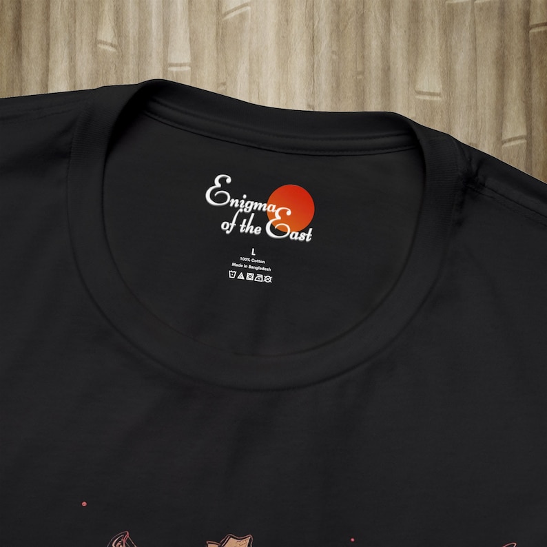 May include: Black t-shirt with a white label that says "Enigma of the East" with a red circle. The label also says "100% Cotton" and "Made in Bangladesh".