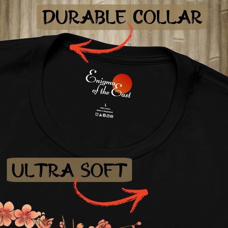 May include: Black t-shirt with a white and red logo that says "Enigma of the East". The shirt has a durable collar and is ultra soft.