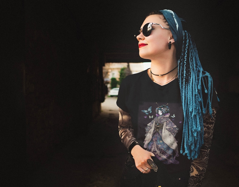 K&ouml;nnte beinhalten: Schwarzes V-Ausschnitt-T-Shirt mit einer Grafik einer Frau in einem Kimono und Schmetterlingen. Der Kimono ist lila und blau. Die Person auf dem Bild tr&auml;gt eine Sonnenbrille und hat blaue Z&ouml;pfe.
