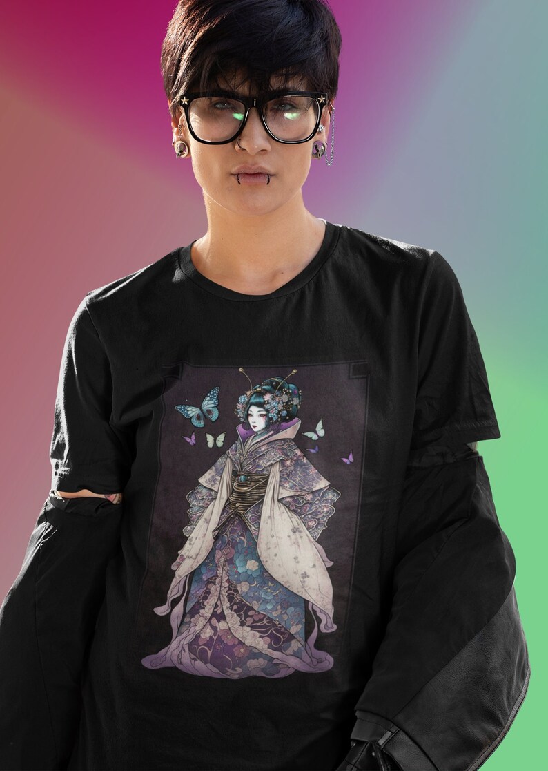 K&ouml;nnte beinhalten: Schwarzes Langarm-T-Shirt mit einer detaillierten Illustration einer Geisha in einem Kimono, umgeben von Schmetterlingen. Die Geisha ist in den Farbt&ouml;nen Lila, Blau und Wei&szlig; dargestellt. Das Shirt hat einen Rundhalsausschnitt.