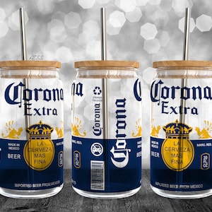 Könnte beinhalten: Drei durchsichtige Glasbecher mit einem Corona Extra Bierdosen-Design. Jeder Becher hat einen Holzdeckel und einen Metallstrohhalm.