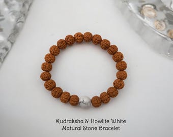 May include: A brown Rudraksha and Howlite White natural stone bracelet. The bracelet is made of small, round beads with a single white bead in the center.
